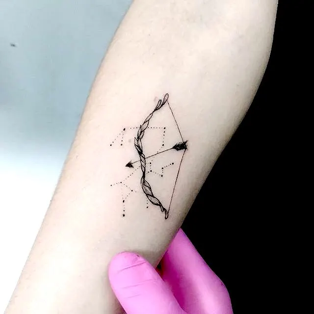 A minimalist bow and arrow forearm tattoo by @nycolaszanotto