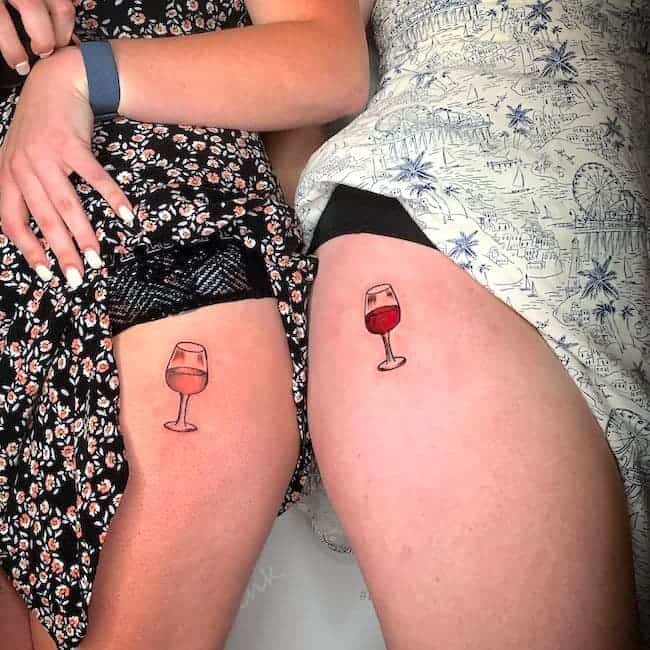 Matching wine glass tattoos on the thigh by @ephanieeee