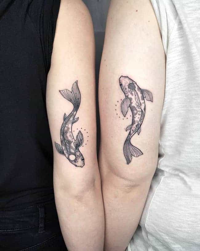 Yin and Yang fish tattoos on the back of the arm by @gayagatto