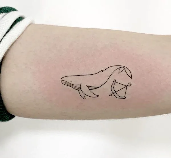 A whale and arrow tattoo on the arm by @bora_tattooer- Creative Sagittarius zodiac tattoo ideas