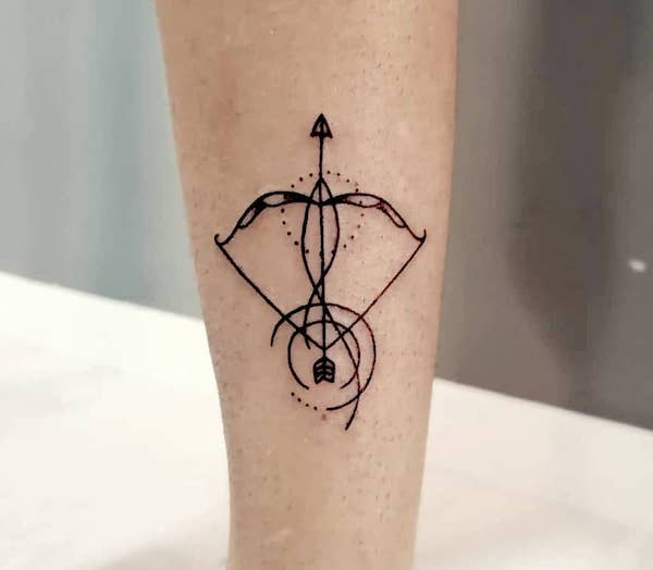 A sleek bow and arrow tattoo by @karen.darkarttattoo- Creative Sagittarius zodiac tattoo ideas
