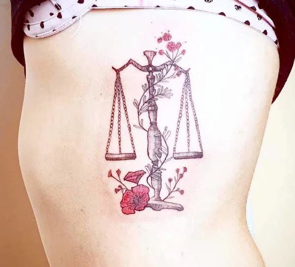 An elegant floral rib tattoo by @shushu_tattoo - Libra symbol and constellation tattoos
