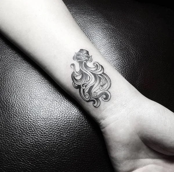 A detailed Water Bearer tattoo that flows on the wrist by @eck.tattoo