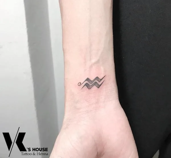 A simple blackwork wrist tattoo for Aquarius men by @khoaartist92
