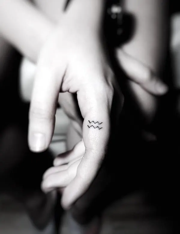 A small Aquarius finger tattoo by @paintedsister