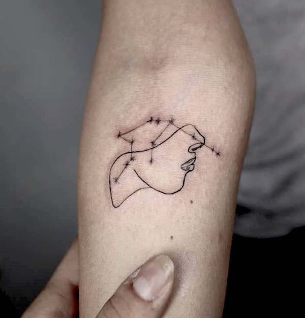 An abstract face tattoo with Aquarius constellation by @inbal_tattoo