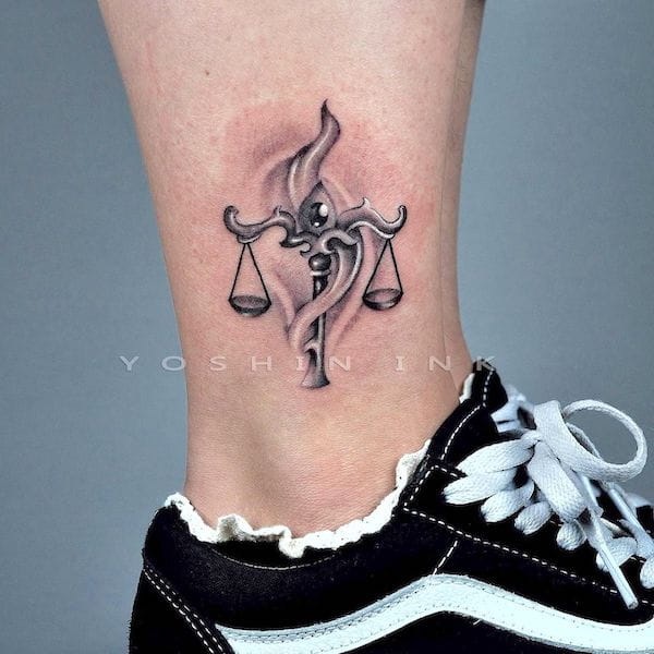 The scale in swirls - a whimsical ankle tattoo by @yoshinink - Bold Libra tattoo ideas for men