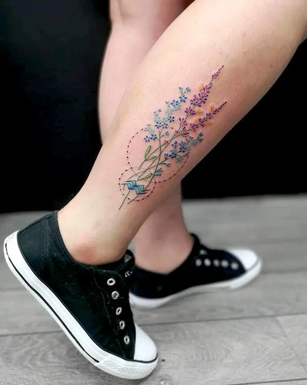 A floral calf tattoo with Aquarius glyph by @totemastattoo