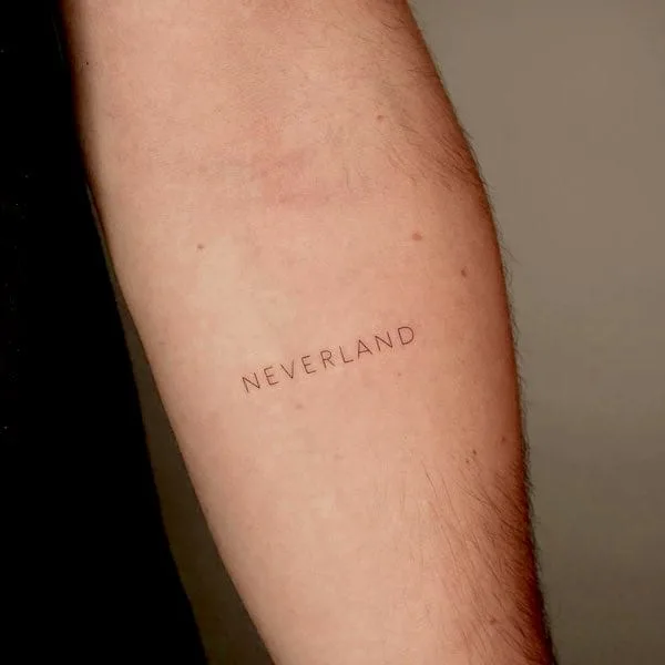 Neverland - a one-word quote tattoo by @keyatattoo
