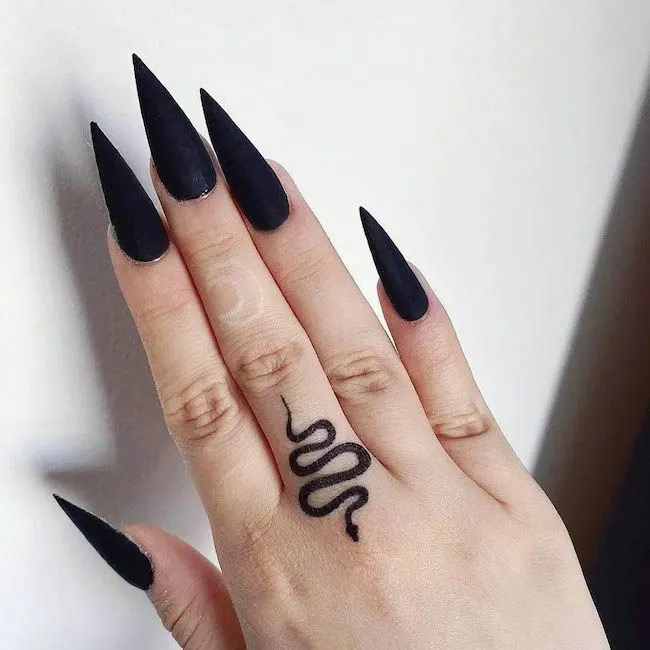 A sleek snake finger tattoo by @charcoaltattooclub - Bold statement finger tattoos