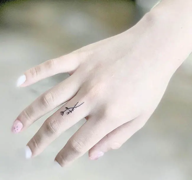 A dainty floral finger tattoo by @chorong_tattooer- Dainty finger tattoo ideas