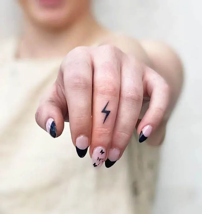 A blackwork lightning tattoo by @garryfineline- Dainty finger tattoo ideas