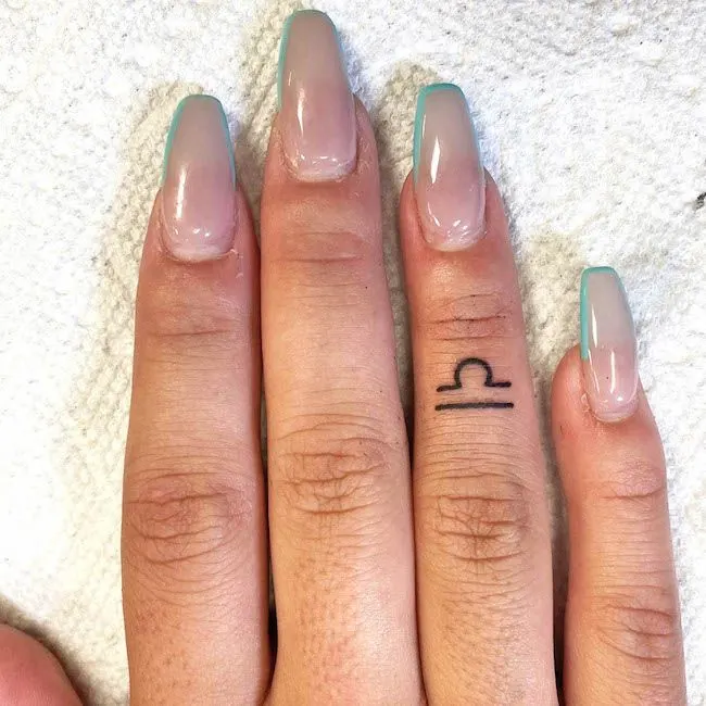 A Libra sign finger tattoo by @jessicalaurentattoo- Dainty finger tattoo ideas
