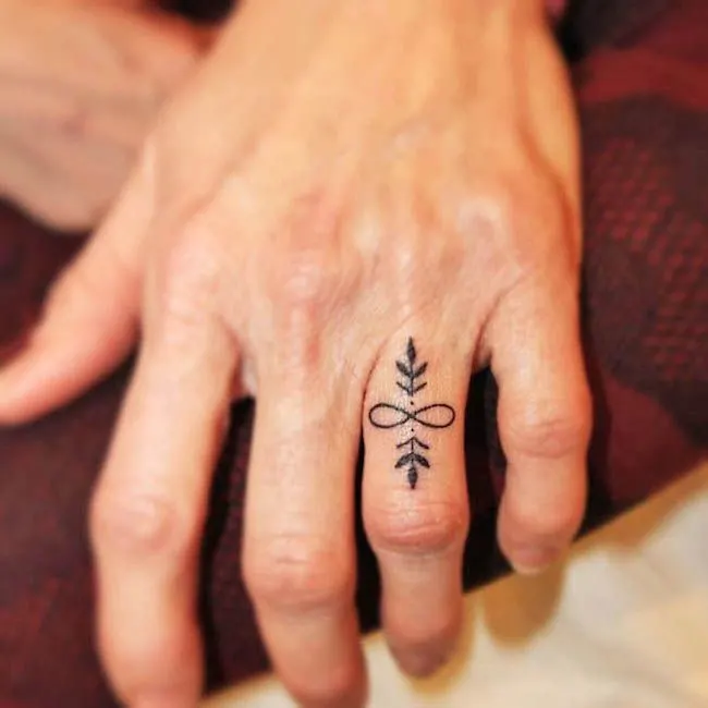 An infinity ring finger tattoo by @lovecrafttattoo