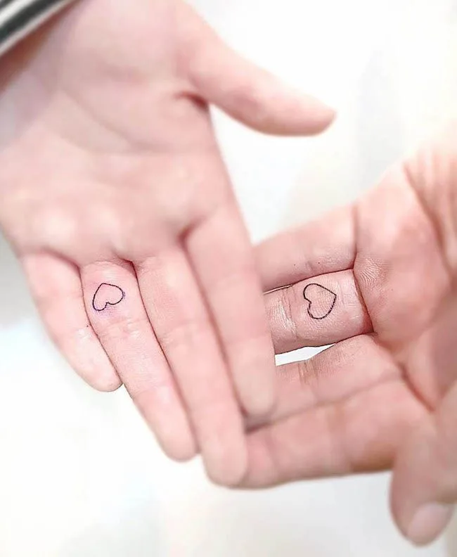 Small heart tattoos on the palm by @morae_tattoo - Matching finger tattoos for couples