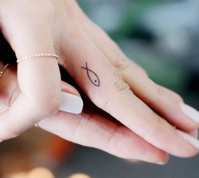 A minimalist fish inner finger tattoo by @onyx_gil- Dainty finger tattoo ideas