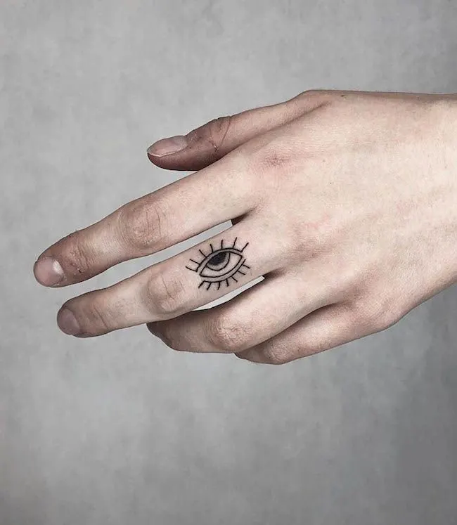 The evil eye middle finger tattoo by @palmer_tattoo - Bold statement finger tattoos