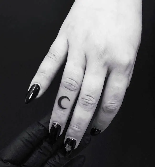 A crescent finger tattoo for women by @royveksler- Dainty finger tattoo ideas