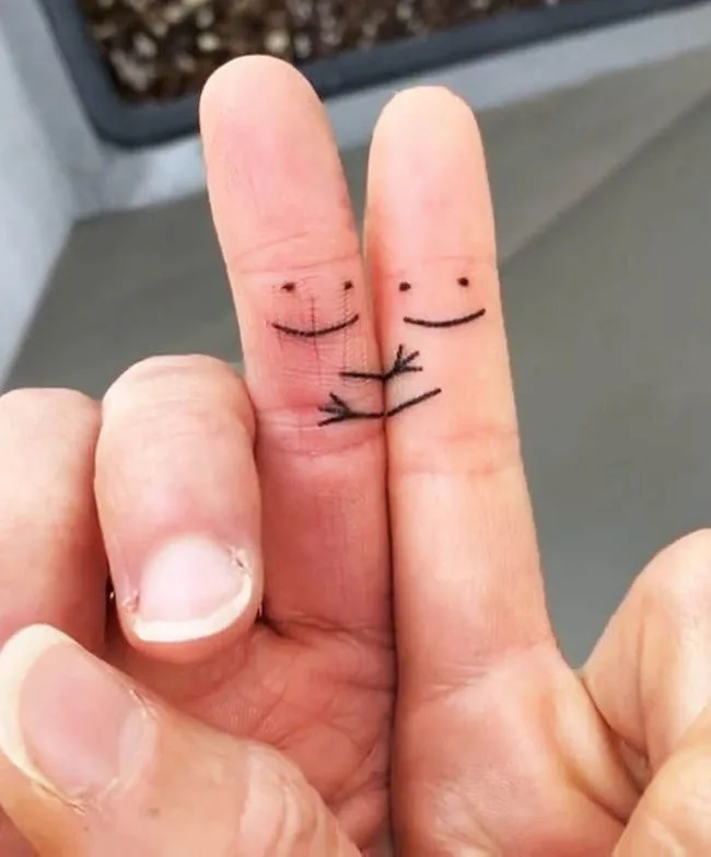 Cute matching smiley faces by @shadow_tattooer - Matching finger tattoos for couples