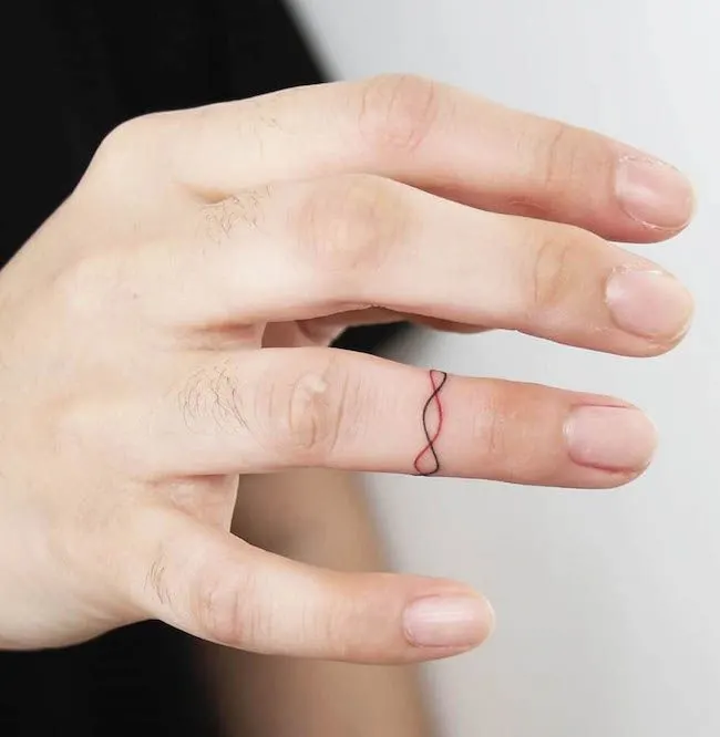 A dual color string tattoo on the ring finger by @tattooist_yara- Dainty finger tattoo ideas