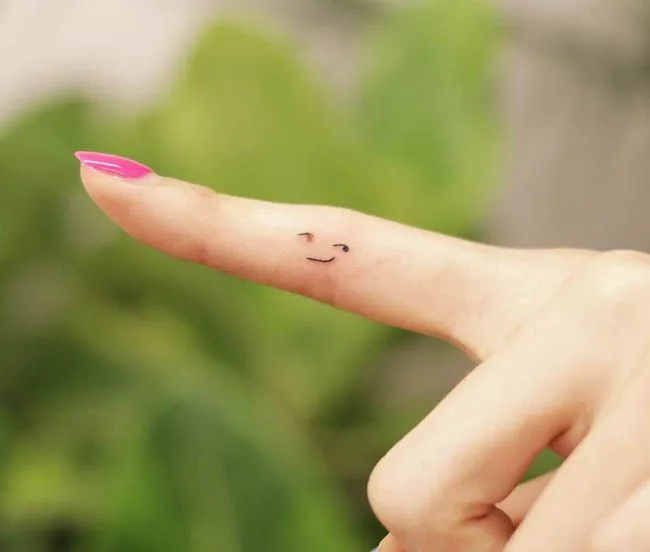 A cute smirk inner finger tattoo by @wittybutton_tattoo- Dainty finger tattoo ideas