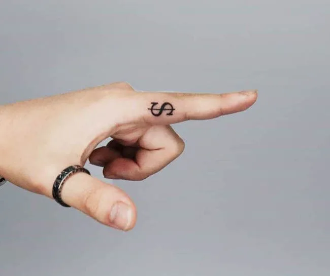 A dollar sign tattoo on the inside of finger by @yujin_tattoo- Dainty finger tattoo ideas