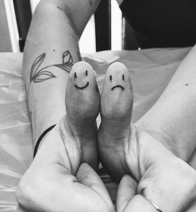 Happy and sad face thumb tattoos by @ziggiestattoo- Creative thumb tattoos