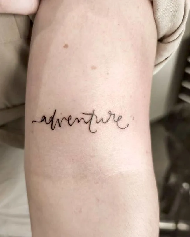 A single-word tattoo for the adventurers by @mikaink