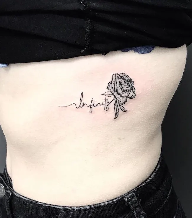 Infinity - a rose tattoo on the ribcage by @bil_tattoo