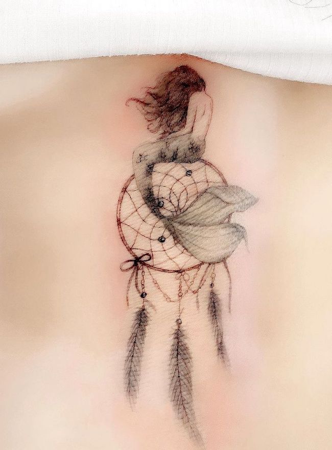 A whimsical dreamcatcher tattoo by @simya_tattoo