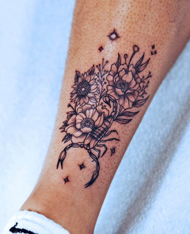 An intricate floral tattoo Scorpio by @rozlyndubztattoos