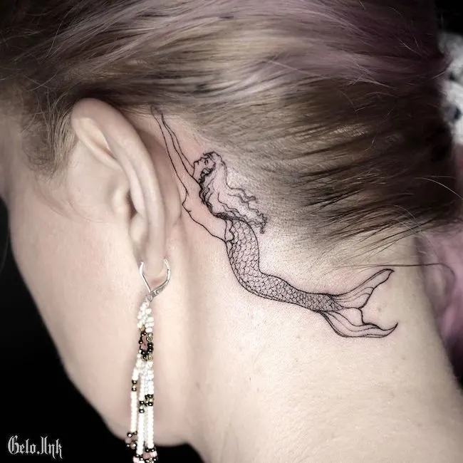 A stunning mermaid tattoo behind the ear by @gelo.ink_