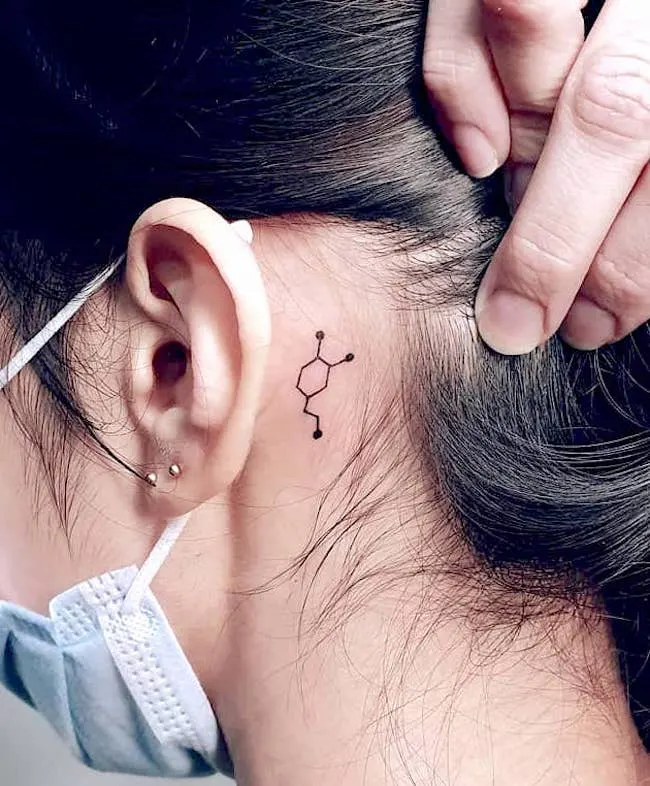 Dopamine tattoo behind the ear by @val_tattooer