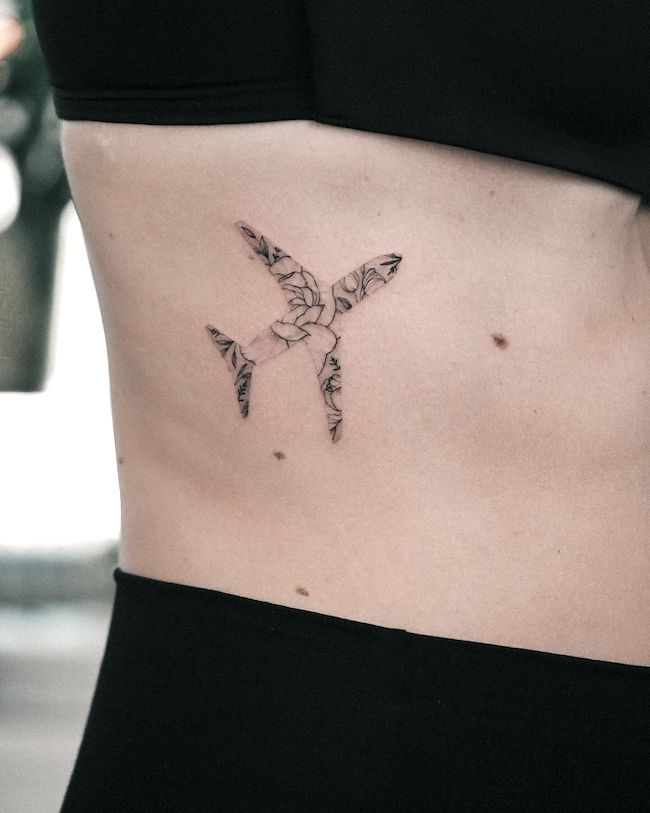 Floral pattern plane tattoo on the ribcage by @bunami.ink