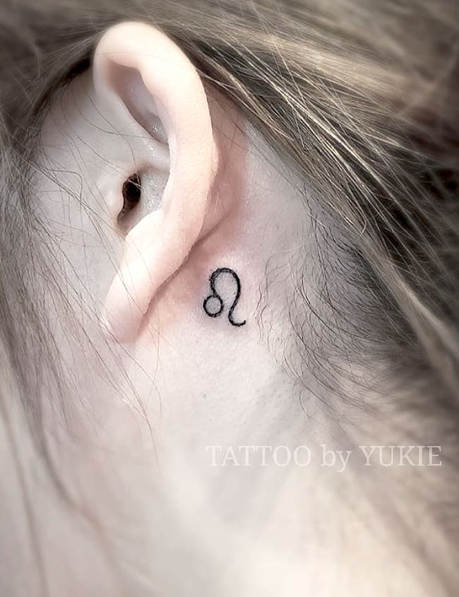 Leo symbol behind the ear by @tattoo_yu77