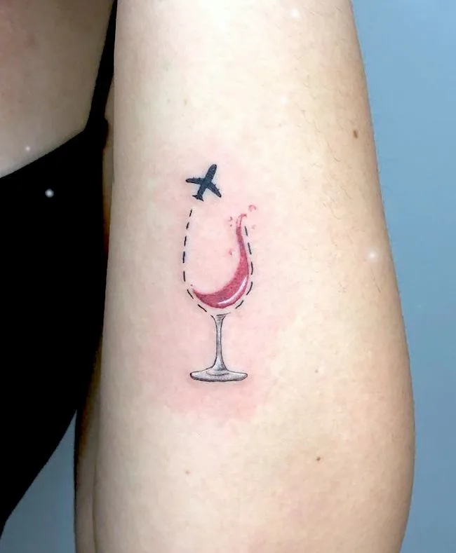 Plane and wine tattoo by @thais.foxtattoo