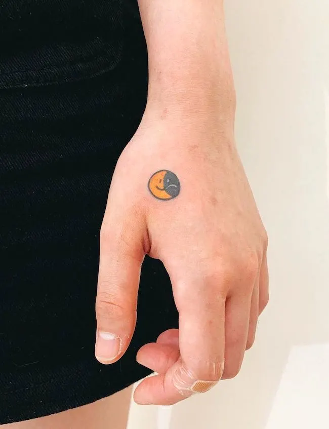 Small happy face sad face tattoo by @angustattoo