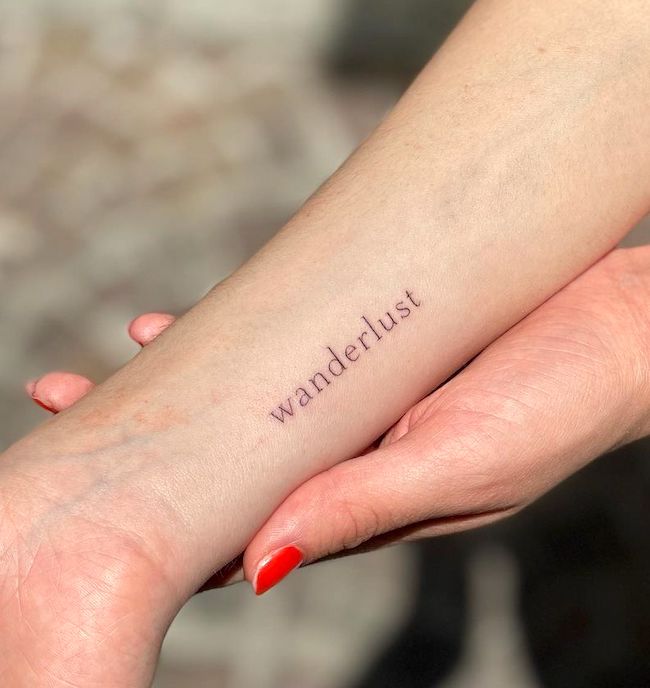 Wanderlust one word tattoo by @stefano__mazza