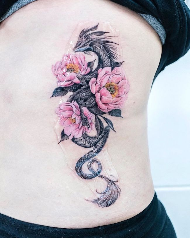 Feminine dragon colored tattoo by @tattooist_color.b - Elegant and Badass Dragon Tattoos For Women with Meaning