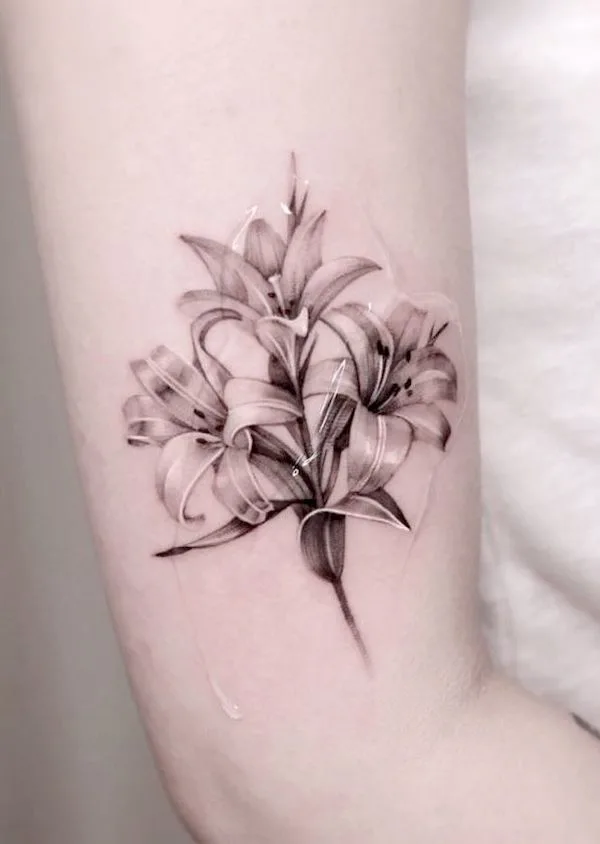 Black and white lily arm tattoo by @jku_tattoo - Lily flower tattoos with meaning