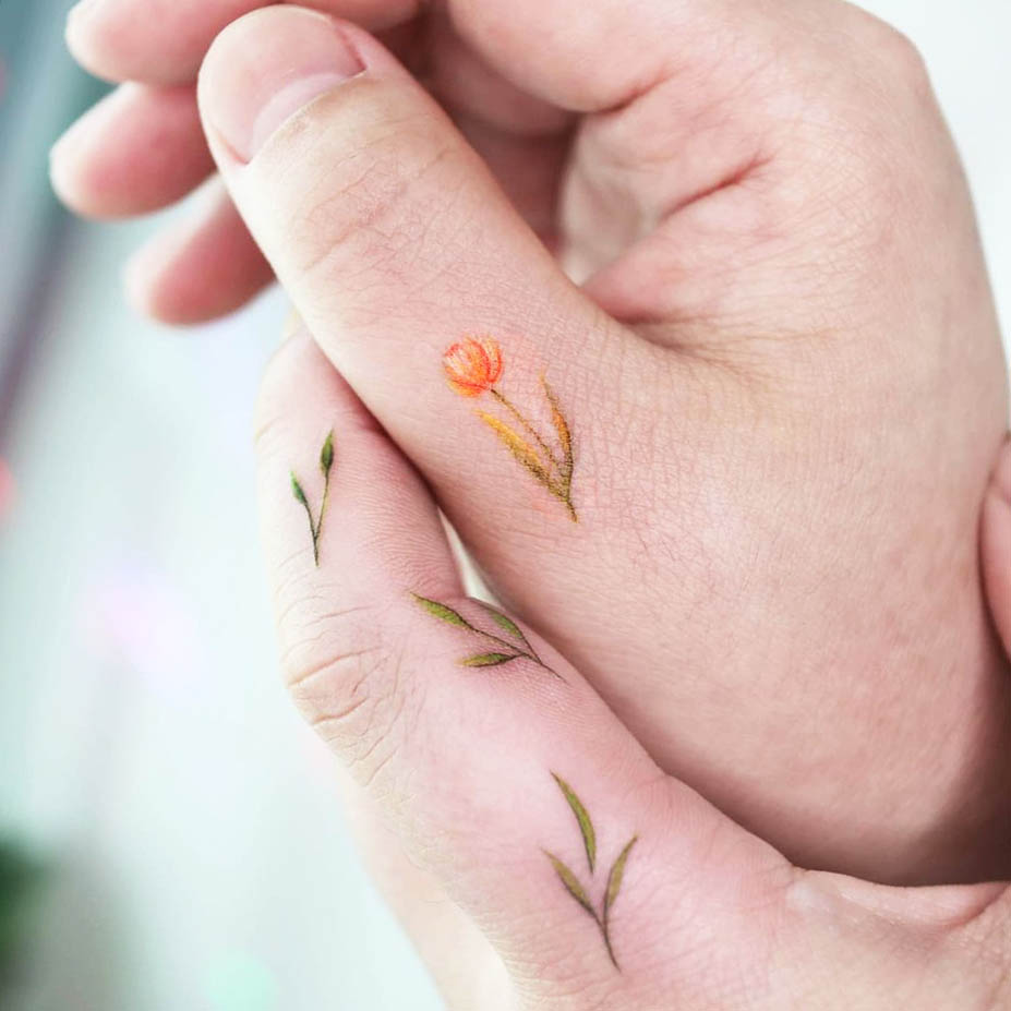 Dainty small tulip finger tattoo by @tattooist_namoo