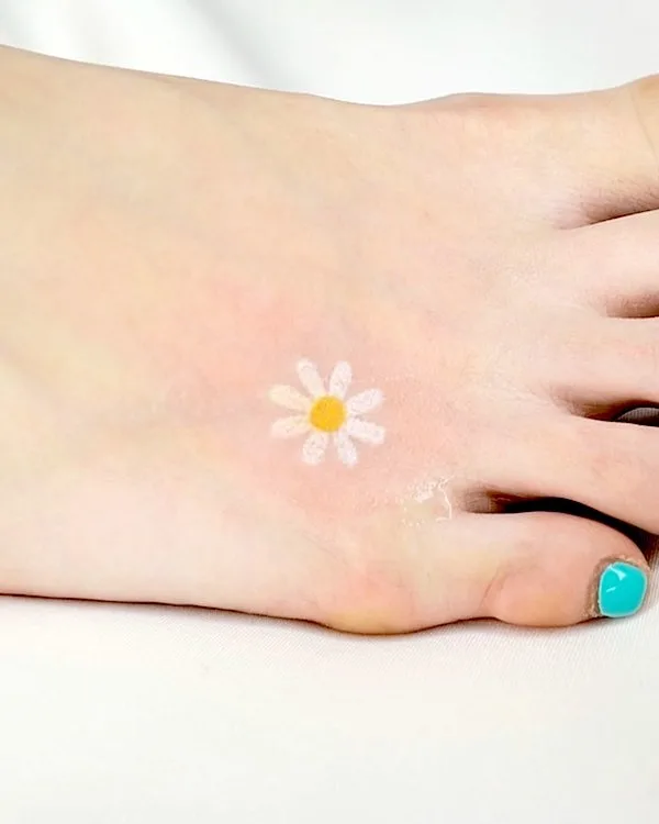 Small and simple daisy foot tattoo by @keenetattoo- Daisy flower tattoos with meaning
