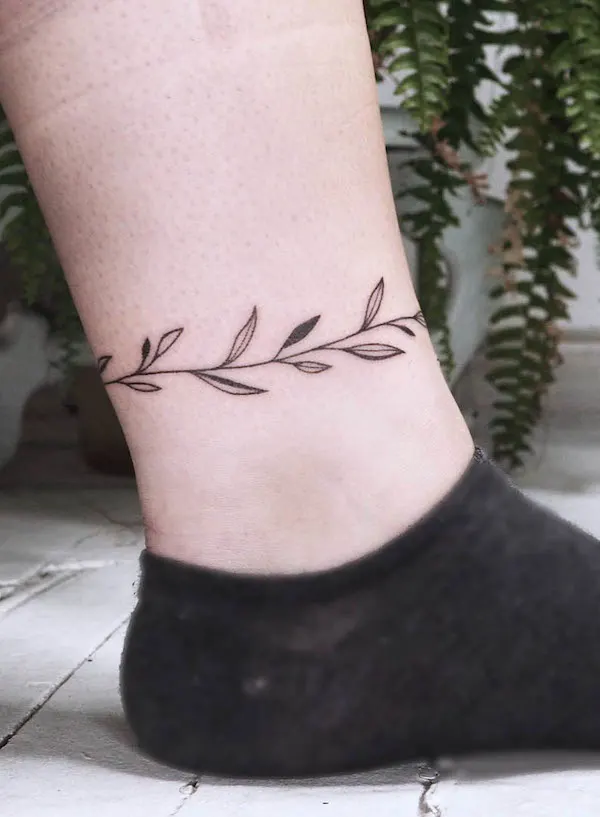 Vine and leaf tattoo around the ankle by @molebulle