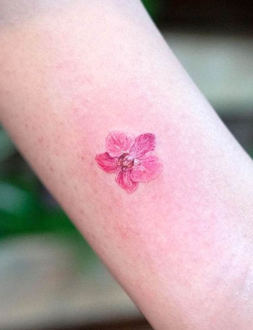 small pink orchid arm tattoo by @mojo_tattoo