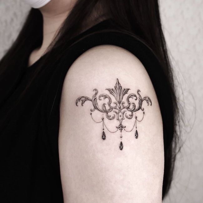 Chandelier shoulder tattoo by @auua.tattoo- Classy black and white shoulder tattoos for women