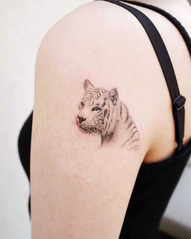 White tiger tattoo on the back of shoulder by @hansantattoo- Classy black and white shoulder tattoos for women