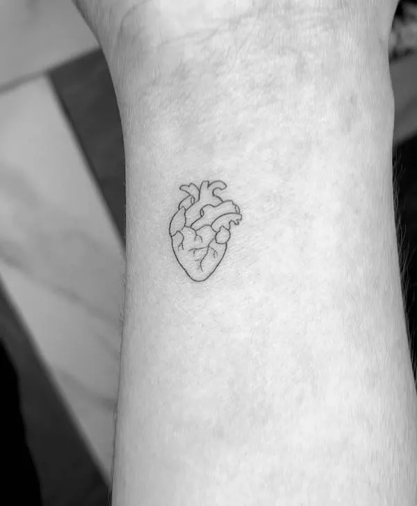 A small heart tattoo on the wrist by @damkstudio
