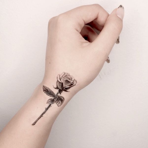 Tiny one line rose tattoo placed on the wrist