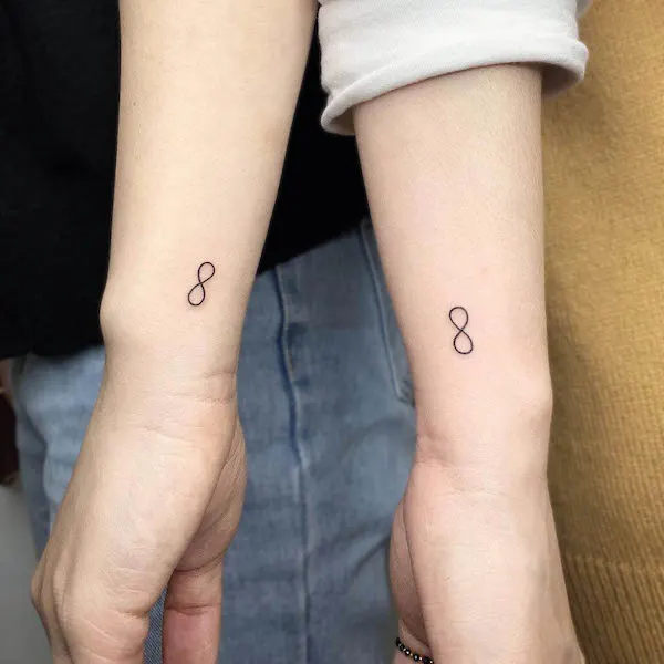Matching infinity wrist tattoos by @bora_tattooer