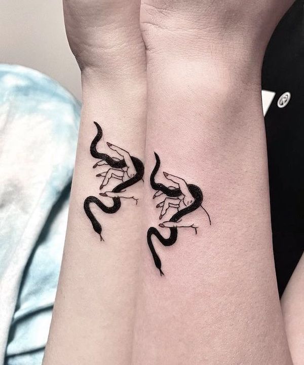 Playing with snake side wrist tattoos by @atar_bar